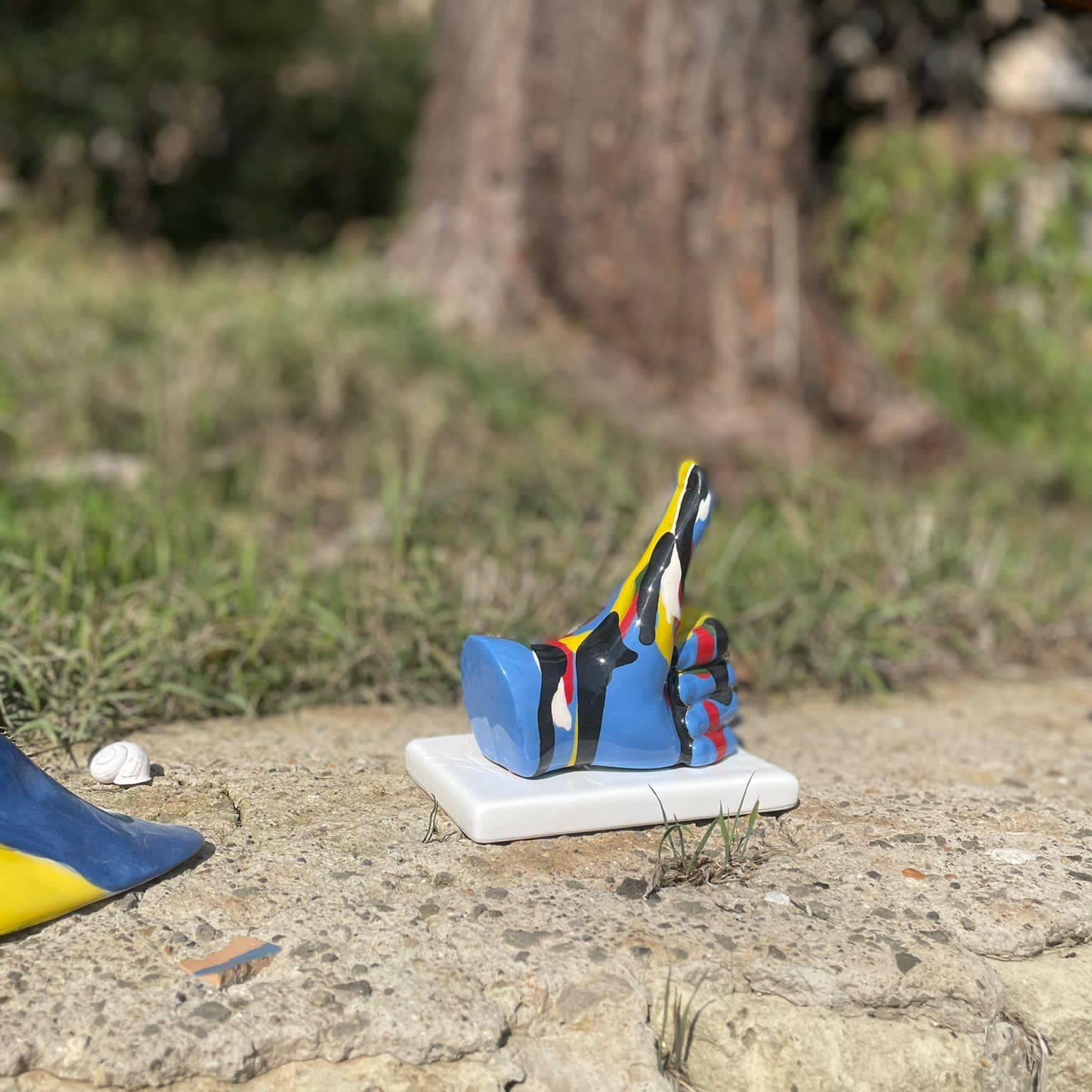 Statua mano "Mi piace" decoro imbratto, base blu, in porcellana lucida. Amage